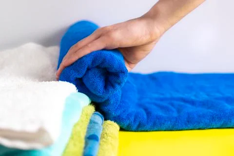 Close up hands lay down stack of clean towels on table Stock Photos