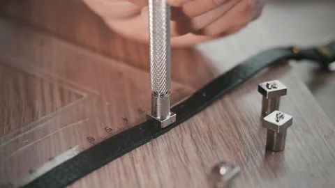 Close up of hands of leather worker in an attempt to stam letter on leather Stock Footage 153195308