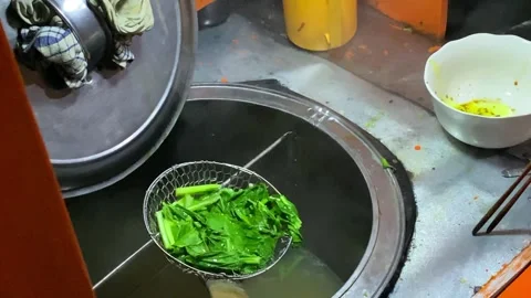 Close-up of hands lifting and draining boiled mustard greens Stock Footage 292907115
