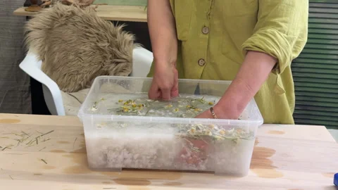 Close-up of hands lifting a paper screen with floral pulp from water. Handmade p Vídeo Stock 313501945
