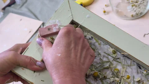 Close-up of hands lifting a paper screen with floral pulp from water. Handmade p Video stock 313502607
