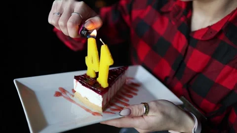 A close-up of hands lighting yellow number candles on a dessert 库存影片 295138545