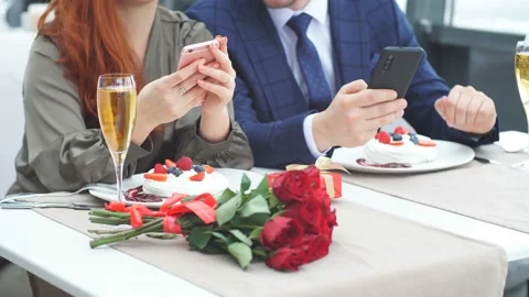 Close-up hands of loved-up couple using smarfon on romantic date at restaurant Stock Footage 124132660