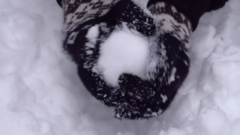 Close up of hands making a ball from snow. Wearing woven gloves. Audio included Stock Footage 148082990