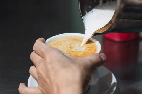 Close-up of hands making a cappuccino. Fotos Stock