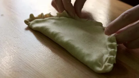 Close-up hands making chebureks. Preparing meat pies Stock Footage 174444315
