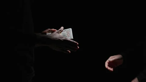 Close up of Hands Making a Deal with a Stack of 100 Dollar Bills in Darkness Video stock 208799510