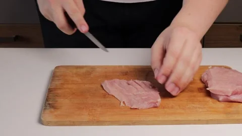 Close-up of hands making shallow diagonal cuts on pork cutlets using a knif.. Stock Footage 320955047
