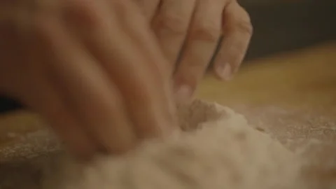 Close-up of hands making well in flour pile 库存影片 336374738