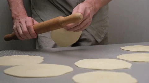 Close-up of the hands of male chef rolling out small cakes of dough. Slow motion Stock Footage 170774335