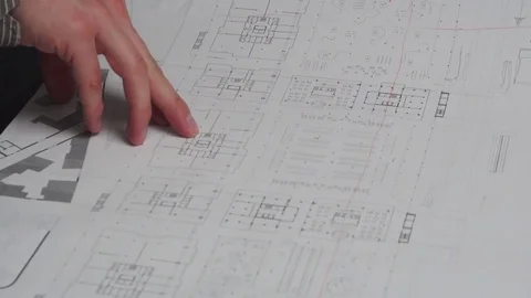 Close up of hands of male design engineer, blueprints laying on his desk Stock Footage 85129110