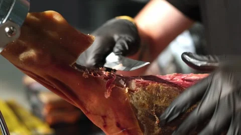 Close up of hands man Chef cutting Extra quality dry-cured spanish ham Jamon Stock Footage 279551456
