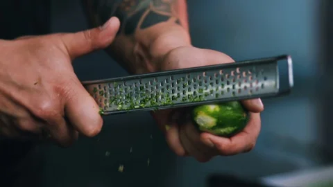 Close up hands man chef rubbing a lime peel on a grater in a restaurant kitchen Stock Footage 100303123
