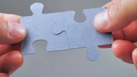Close Up Hands of man Connecting Jigsaw Puzzle With Sunlight Affect. Business Stock Footage 223380842