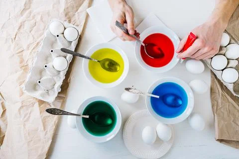 Close up hands Man dyeing Easter eggs with liquid food coloring. Flat lay. Stock Photos