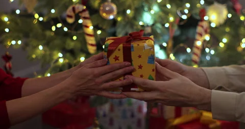 Close-up hands of man giving festive box with Christmas present to woman during Stock Footage 221484071