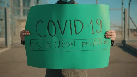 Close up hands man hold poster COVID-19 is a global problem wearing protective Stock Footage 126585067