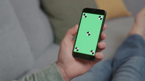 Close up hands man lying on couch with modern smartphone with mock up green Vídeos de archivo 220202731