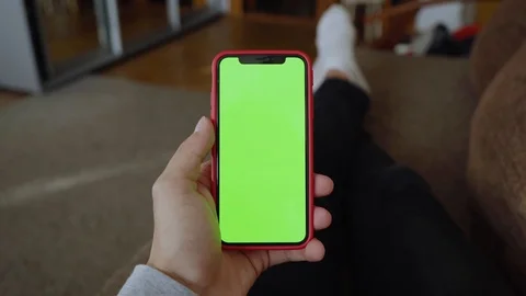 Close up hands man lying on sofa use vertical green screen phone at home living Stock Footage 118472621