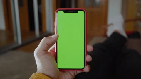 Close up hands man lying on sofa use vertical green screen phone at home living Stock Footage 118472704