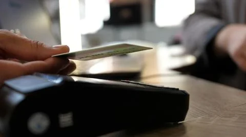 Close up hands of man making payment with credit card machine terminal while Stock Photos