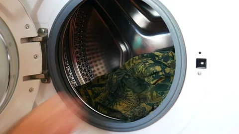 Close-up of the hands of a man opening the door of a washing machine and put Stock Footage 169911821