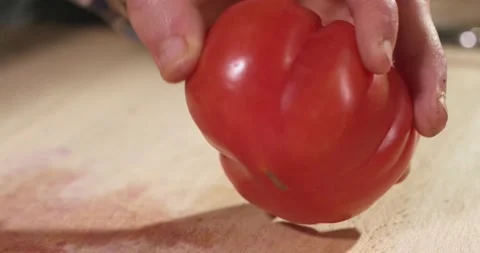 Close up of hands of a man peeling a tomato. 動画素材 154849460