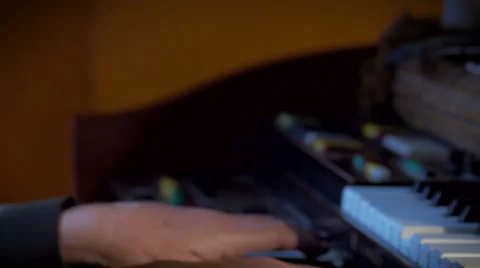 Close up of hands of a man playing an organ pan down across keyboard Stock-Footage 52695473