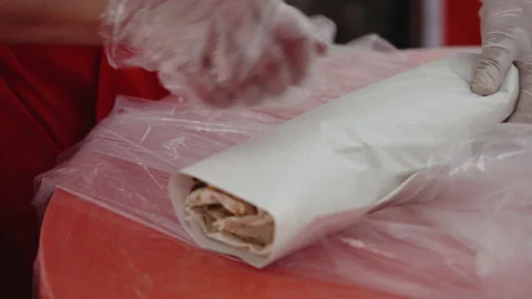 Close-up of the hands of a man in a protective glove preparing a tortilla. chef Stock Footage 230609261