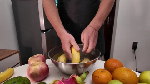 Close-up of the hands of a man, standing in front of a table with fruit Stock Footage 332200993