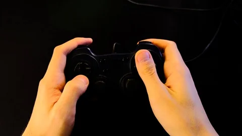 Close-up of hands. Man uses a black controller to play video games on game conso Stock Footage 130055320