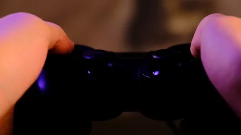 Close-up of hands. Man uses a black controller to play video games on game conso Stock Footage 130055342