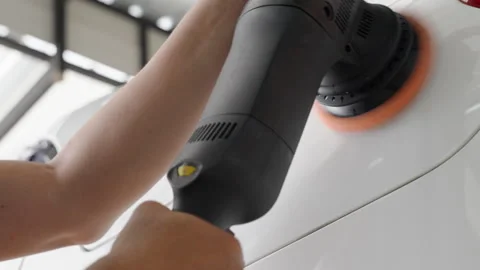 Close up hands of a man using an electric car wax polisher to wax the car Stock Footage 246121999