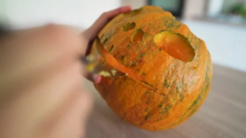 A close-up of the hands of a man using knife to cut out a funny face from a.. Stock Footage 272462801