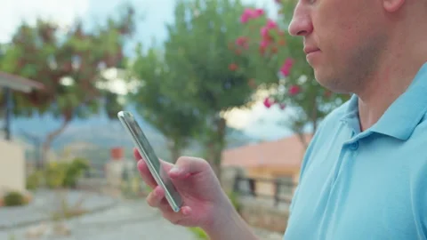 Close-up of hands of man using mobile phone outdoors. Man browsing app Stock Footage 306126525