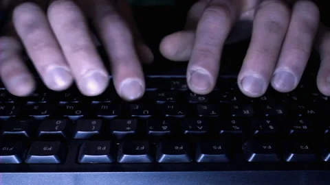 Close up hands of man working on computer in dark room, fingers typing on keys Stock Footage 202226258