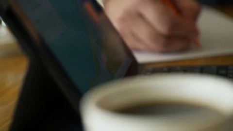 Close up hands of man working writing notes sitting on table in cafe Stock Footage 78550210