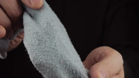 A close-up in the hands of a man is a worn-out sock made of fabric in pellets. Video stock 166507296