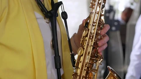 Close-up of the hands of a man in a yellow jacket playing the saxophone. Stock Footage 335680934