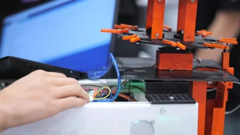 Close-up of hands managing cables near a 3D printer during operation Stock Footage 345918391