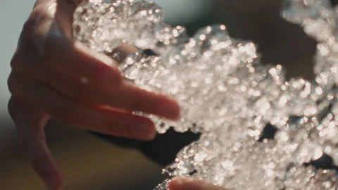 Close up hands manipulating large clear crystalline textured frozen sculpture Stock Footage 345045899