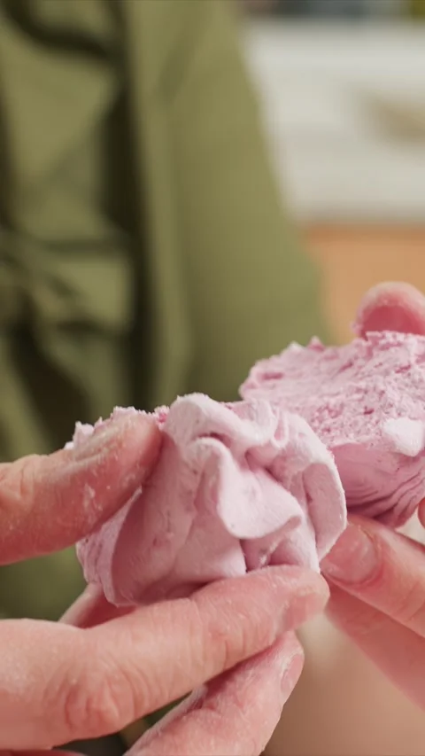 Close up of hands manipulating pink crumbly substance revealing texture and Stock Footage 344422017
