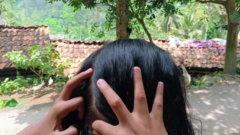 Close-up of hands manually searching for and removing lice from hair. 스톡 동영상 321935924
