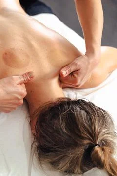 Close up of hands massaging client upper back gently on white massage indoors Foto stock