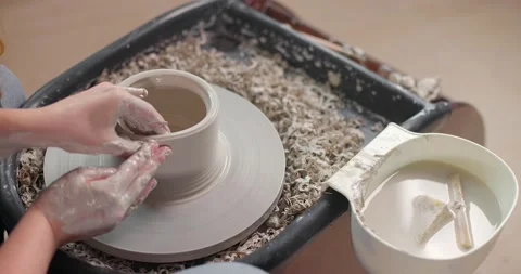 Close-up of the hands of a master potter working on a potter's wheel, forming a Stock Footage 155653536