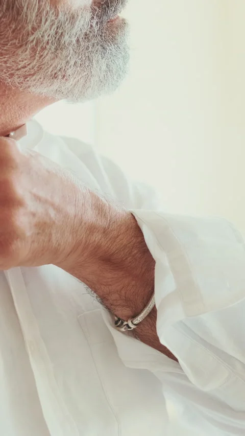 Close-up of the hands of mature man putting on white shirt Stock Footage 229508274
