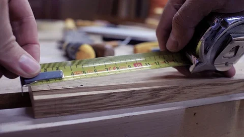 Close-up hands measuring the length of the board with a metal tape measure. Stock Footage 116474367