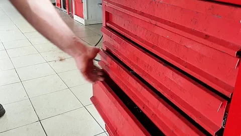 Close-up of hands of mechanic folding working tools in red metal box Stockbeeldmateriaal 122288173