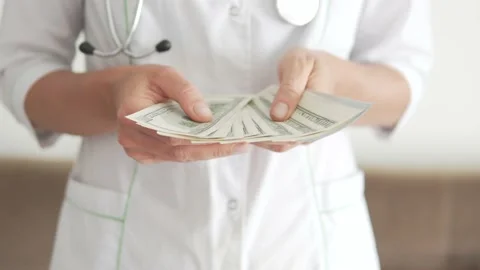 Close-up of hands, a Medina nurse counting dollars, the salaries of medical Stock Footage 239724968