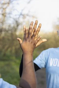 Close up of hands meeting in high five after successful environmental work Stock Photos
